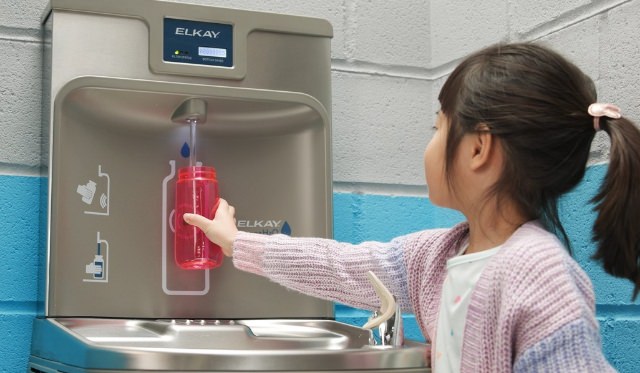 petite fille remplit sa gourde d'eau